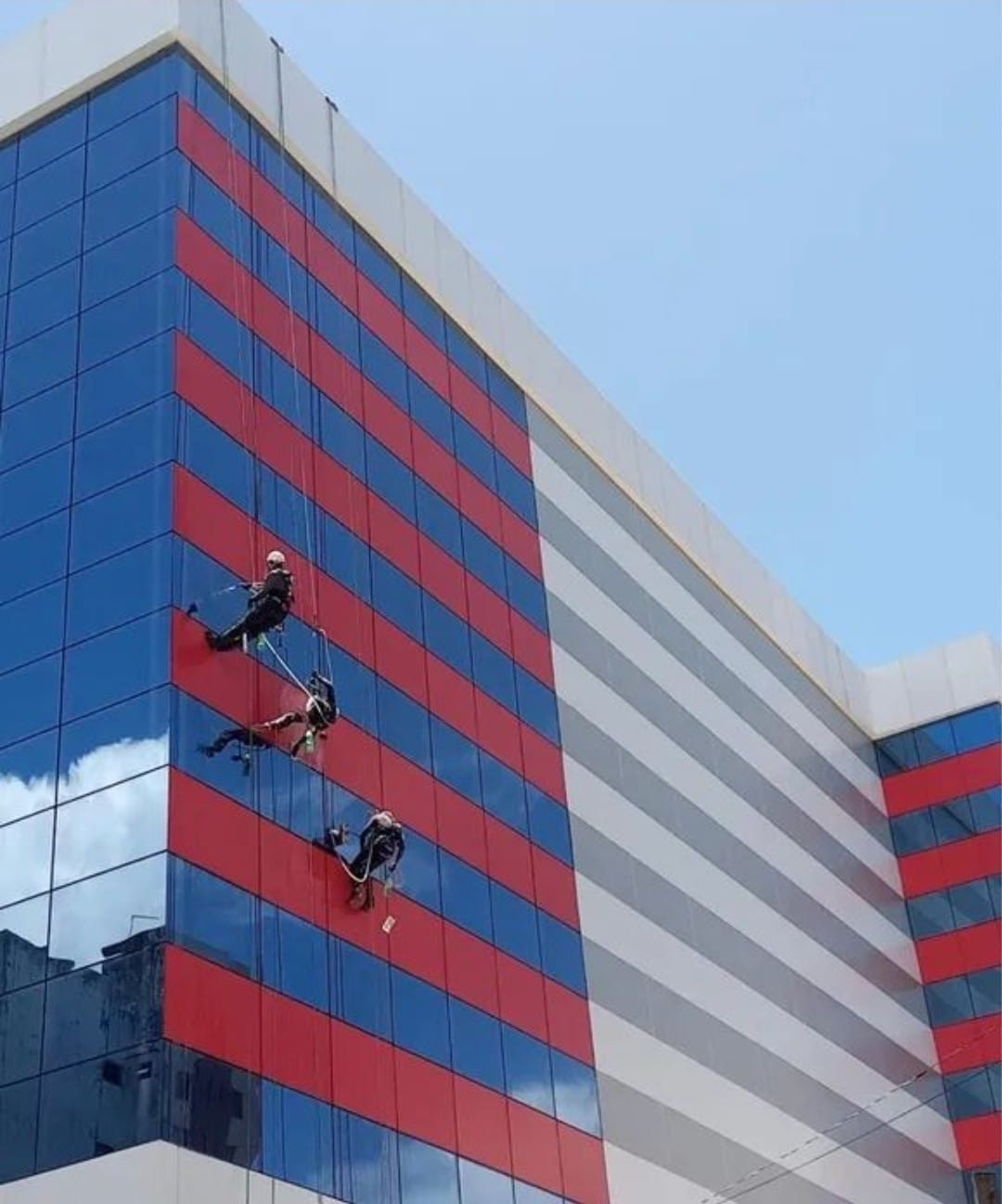 Homens executando serviço em altura em um prédio